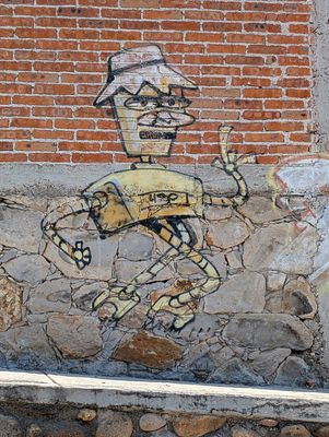 Long-limbed figure in a hat
